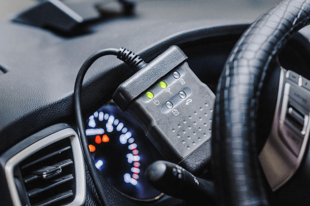 OBD diagnostic interface with illuminated indicators beside a vehicle steering wheel
